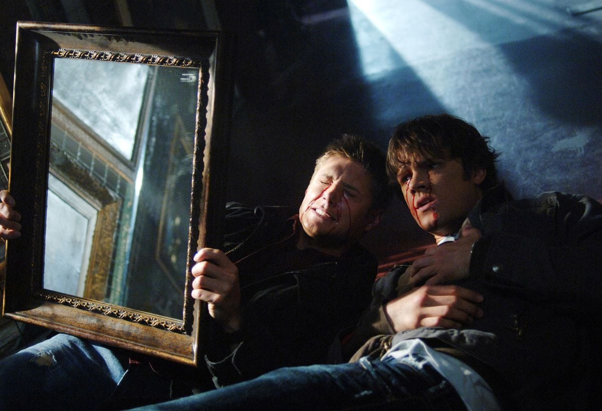 Amidst expressionistic lighting, Sam and Dean employ a mirror to ward off evil in the Season 1 episode “Bloody Mary.”