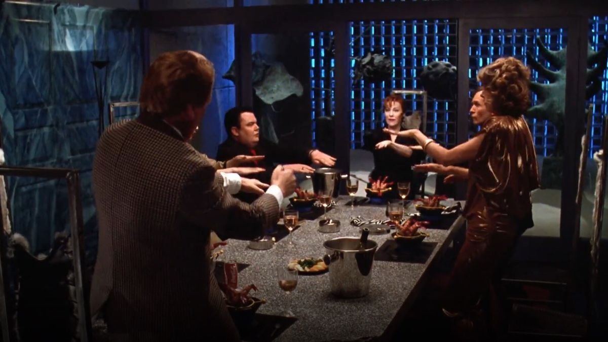 The dinner party scene showcases the dark, moody, industrial-style atmosphere of the re-modeled home and Ackerman’s lighting.